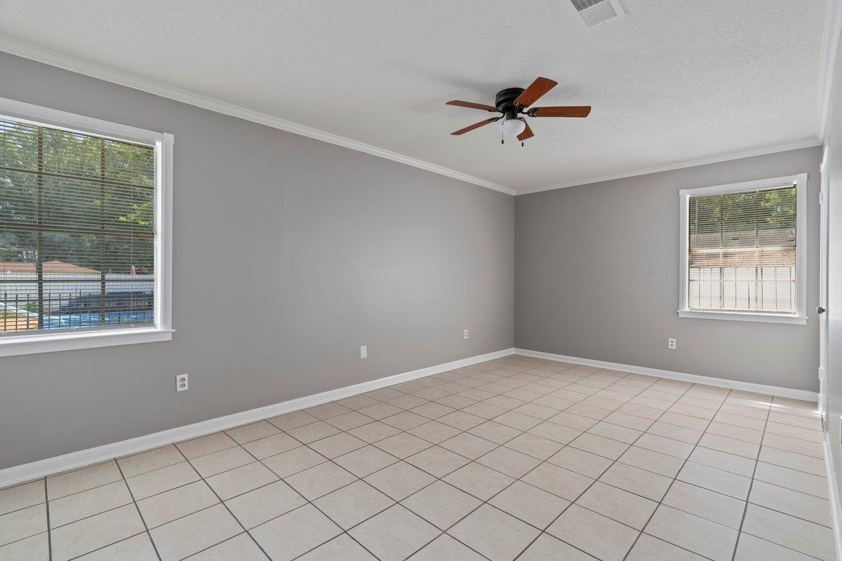 3384 South Mendenhall Road Memphis, TN 38115 - Photo 14 of 22 Empty room with plenty of natural light, ceiling fan, and light tile patterned flooring