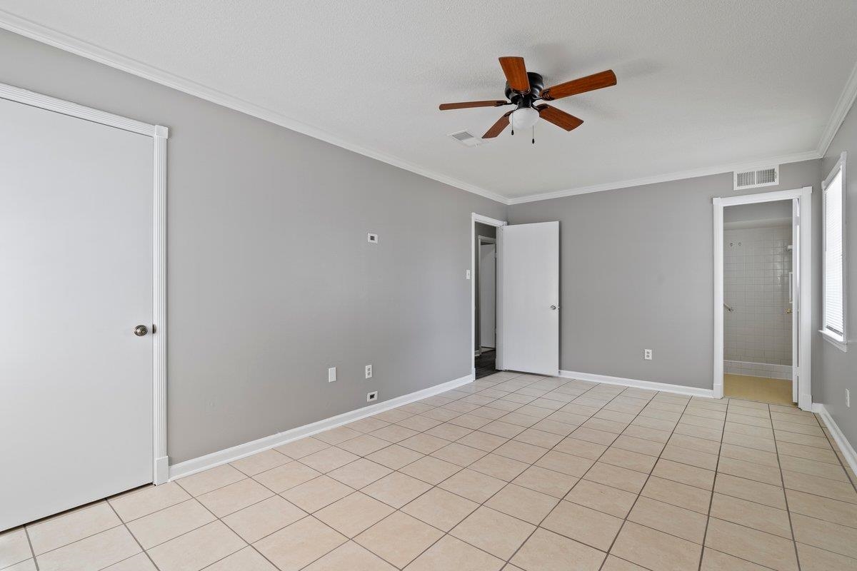 3384 South Mendenhall Road Memphis, TN 38115 - Photo 15 of 22 Empty room featuring ceiling fan, crown molding, and light tile patterned floors