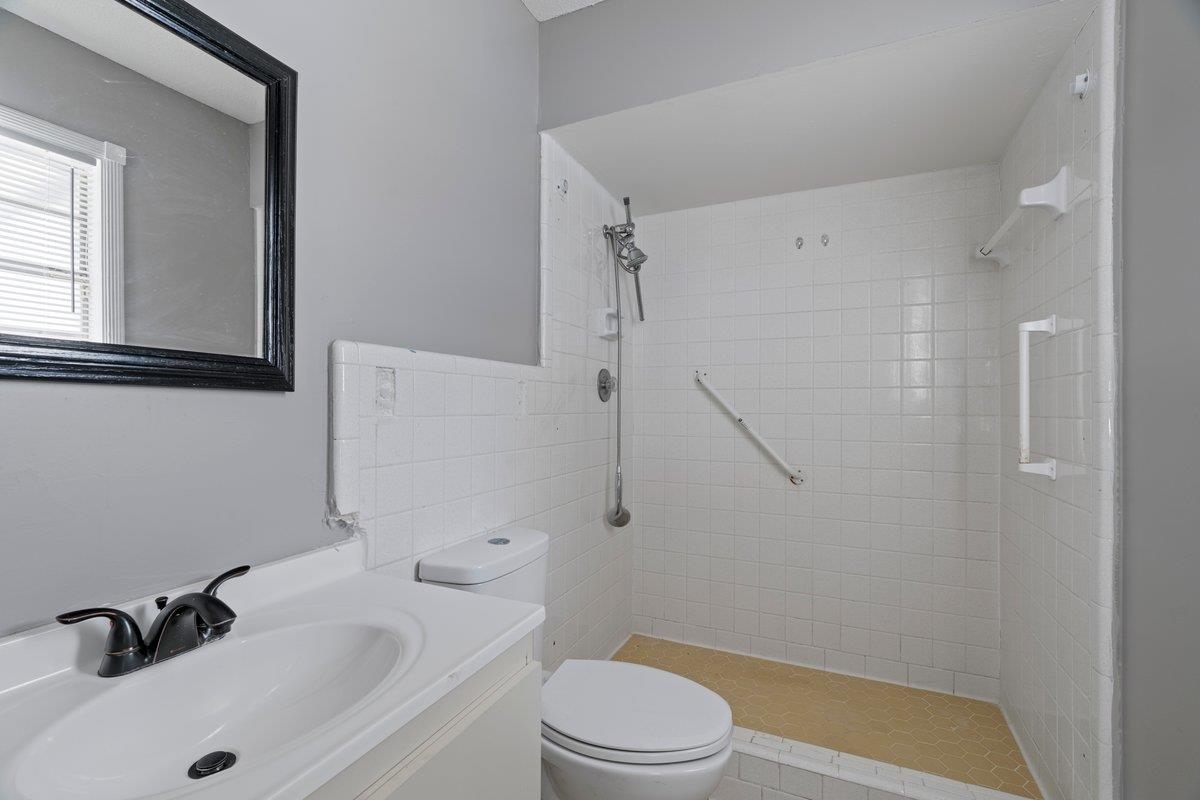 3384 South Mendenhall Road Memphis, TN 38115 - Photo 16 of 22 Bathroom featuring tiled shower, toilet, and vanity