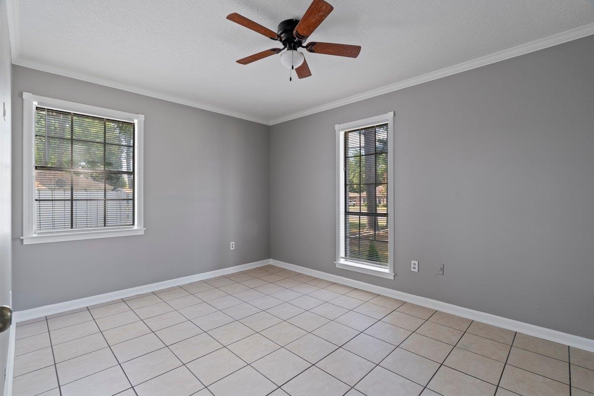 3384 South Mendenhall Road Memphis, TN 38115 - Photo 17 of 22 Tiled empty room with ceiling fan, a wealth of natural light, and crown molding