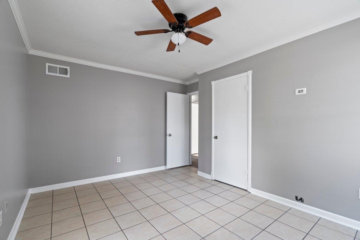 3384 South Mendenhall Road Memphis, TN 38115 - Photo 18 of 22 Unfurnished bedroom with ceiling fan, crown molding, and light tile patterned floors