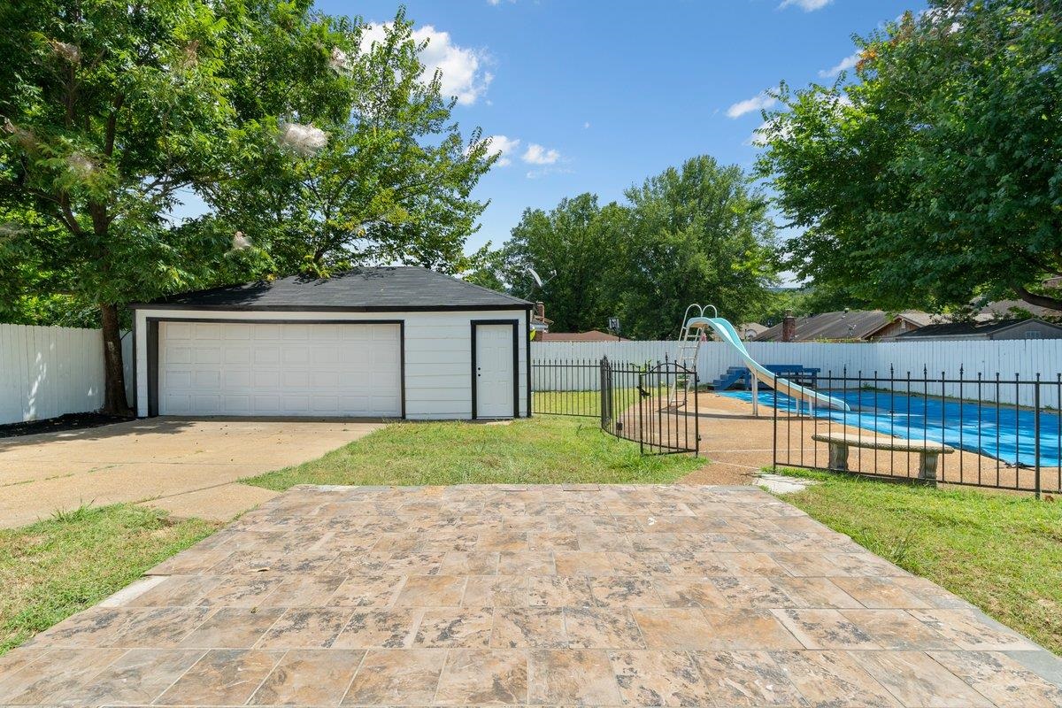 3384 South Mendenhall Road Memphis, TN 38115 - Photo 19 of 22 Exterior space featuring a garage, an outbuilding, and a fenced in pool