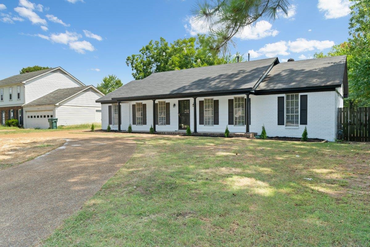 Single story home with a garage, a front lawn, and covered porch