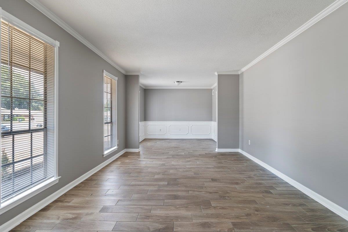Spare room with a textured ceiling, ornamental molding, and wood-type flooring