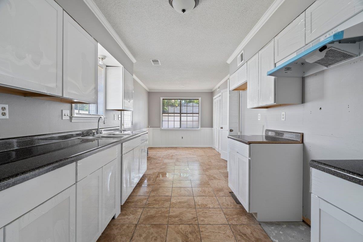3384 South Mendenhall Road Memphis, TN 38115 - Photo 10 of 22 Kitchen featuring sink, light tile patterned floors, white cabinetry, and ornamental molding