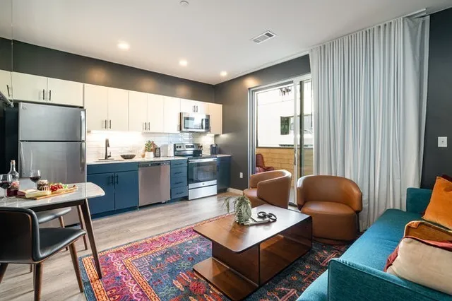 a kitchen with granite countertop a sink cabinets stainless steel appliances and a window