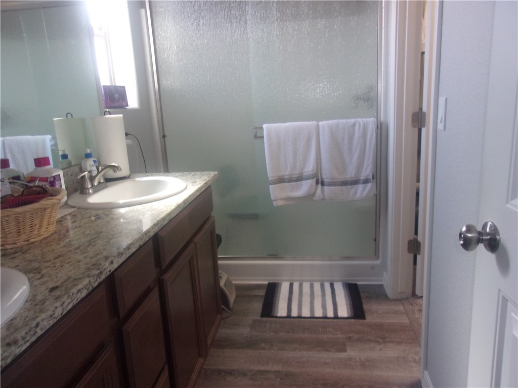 5414 Eagle View Road Kingman, AZ 86409 - Photo 14 of 39 Full bathroom with a shower stall, double vanity, and dark wood-type flooring