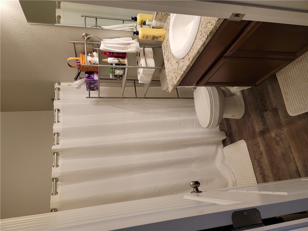 5414 Eagle View Road Kingman, AZ 86409 - Photo 21 of 39 Full bath with a shower with shower curtain, dark wood finished floors, vanity, and a textured wall