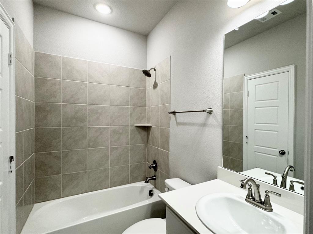 6408 Rienzi Drive Greenville, TX 75402 - Photo 16 of 20 a bathroom with a sink mirror toilet and bathtub