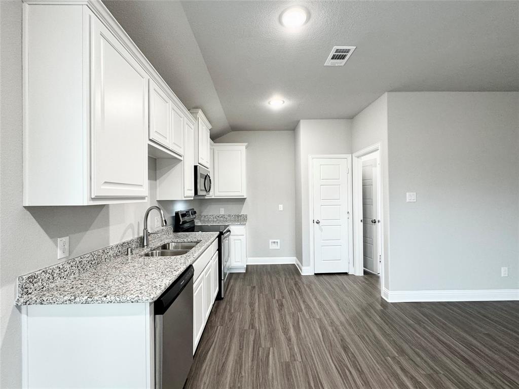 6408 Rienzi Drive Greenville, TX 75402 - Photo 6 of 20 a kitchen with a sink stove top oven and cabinets