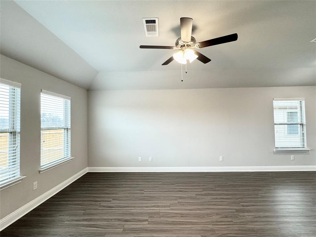 6408 Rienzi Drive Greenville, TX 75402 - Photo 8 of 20 an empty room with wooden floor fan and windows