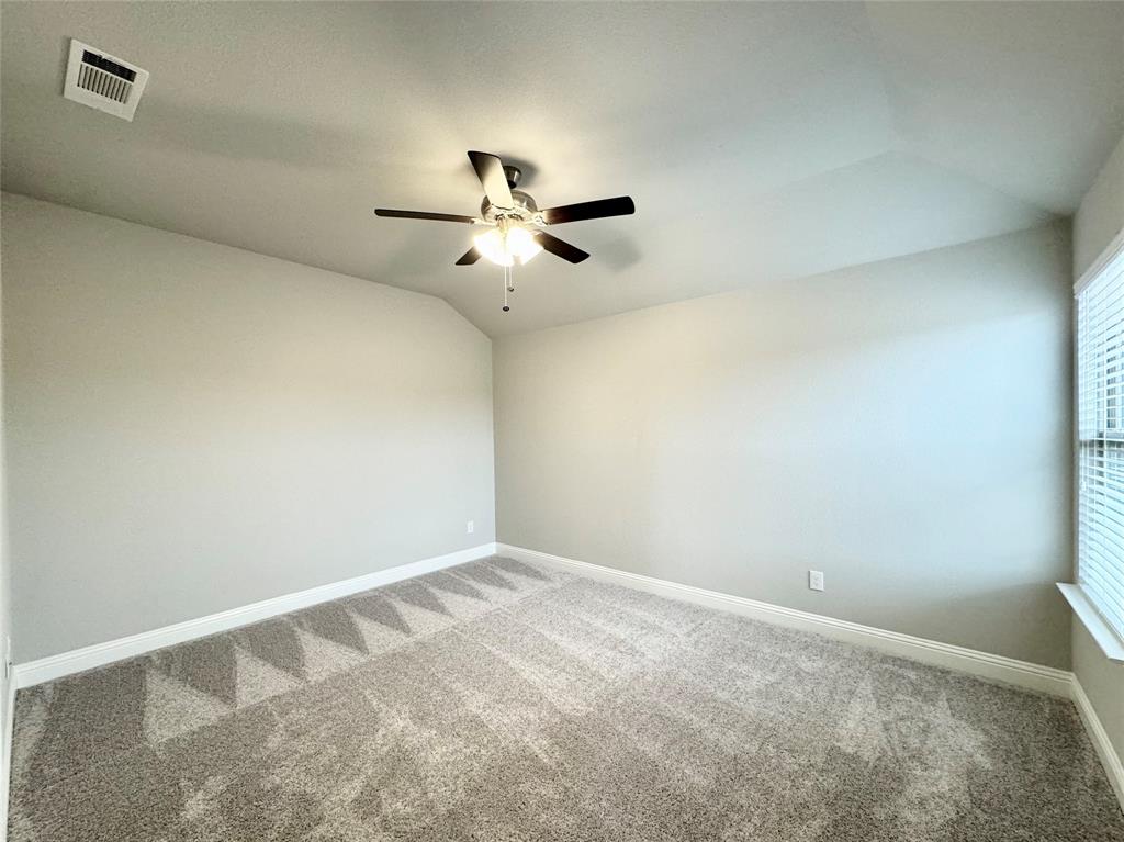 6408 Rienzi Drive Greenville, TX 75402 - Photo 10 of 20 an empty room with a ceiling fan and a window