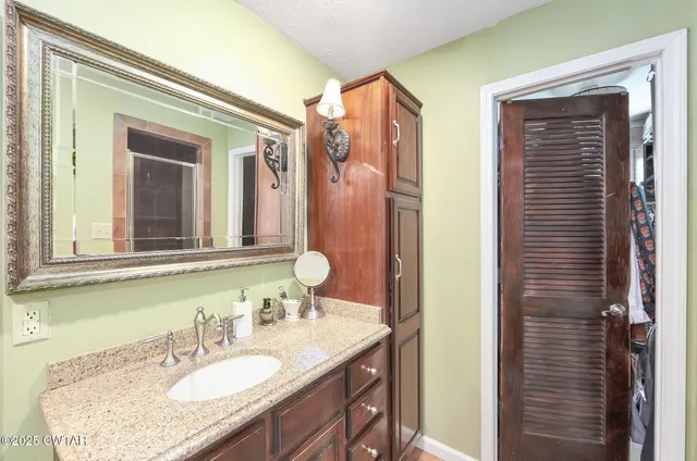 a bathroom with a granite countertop sink and a mirror