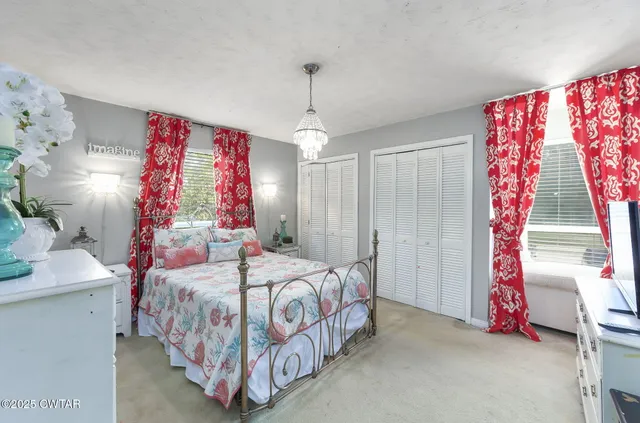 a bedroom with a bed and a flat tv screen on dresser
