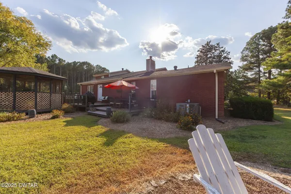 a view of a backyard with table and chairs under an umbrella