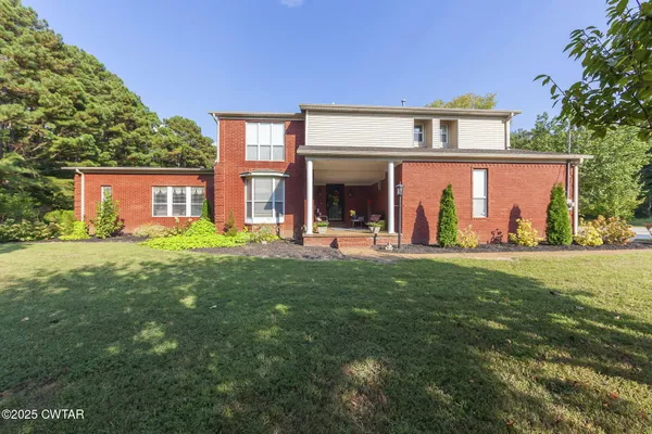 a front view of house with yard and green space
