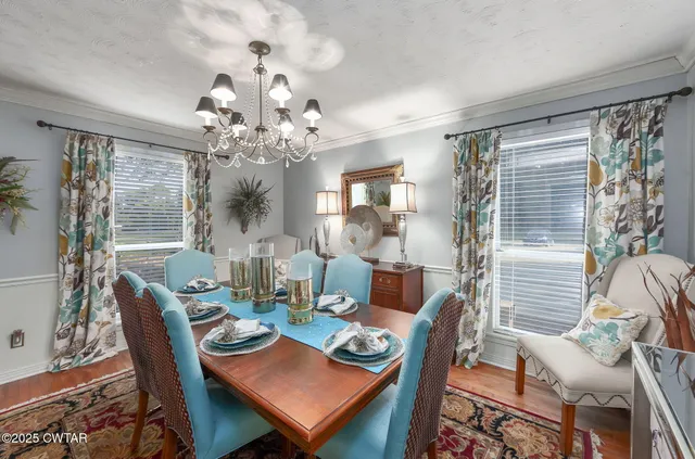 a view of a dining room with furniture and a chandelier
