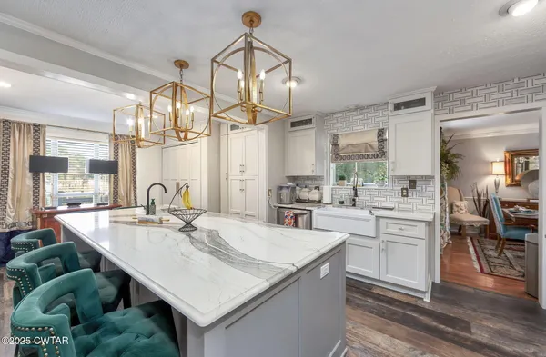 a kitchen with a table chairs refrigerator and cabinets