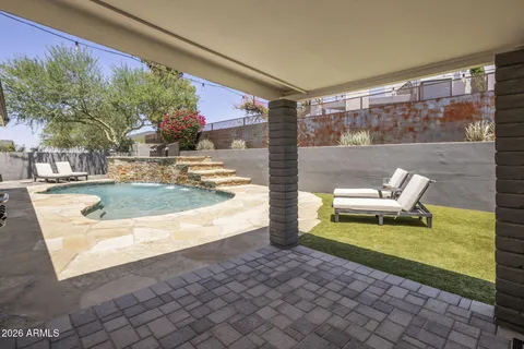 a view of a patio with couches table and chairs with wooden fence