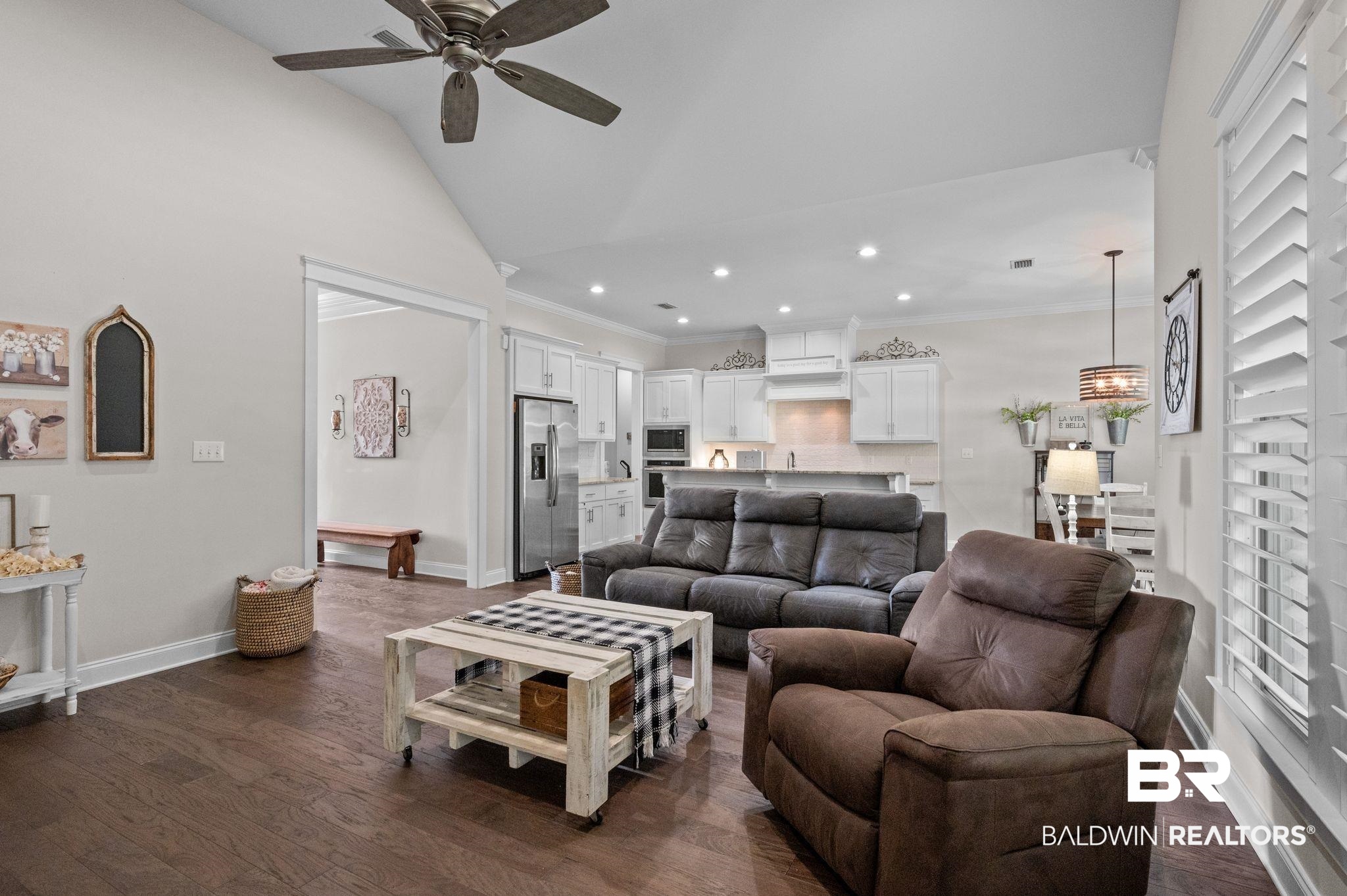 32194 Badger Court Daphne, AL 36527 - Photo 9 of 49 Living room with ceiling fan, dark wood finished floors, crown molding, lofted ceiling, and recessed lighting