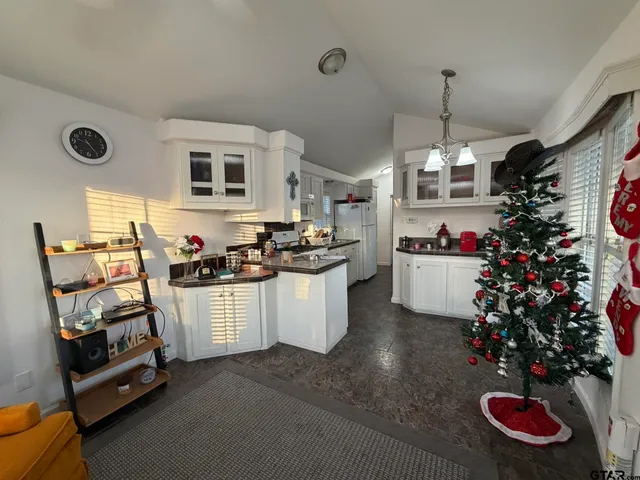 a kitchen that has a lot of white cabinets and stainless steel appliances