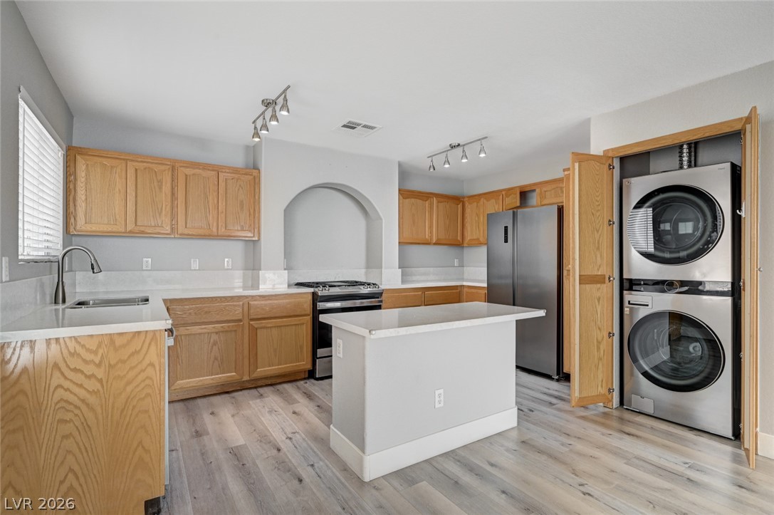 7259 Cestrum Road Las Vegas, NV 89113 - Photo 9 of 35 A well-equipped kitchen featuring an island with a white countertop and sleek, light wood cabinetry.