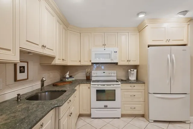 a kitchen with white cabinets sink and white appliances