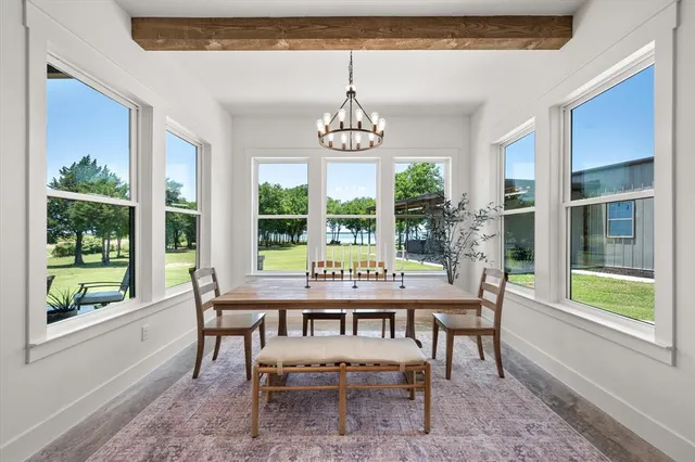 a dining room with wooden floor a chandelier a wooden table and chairs