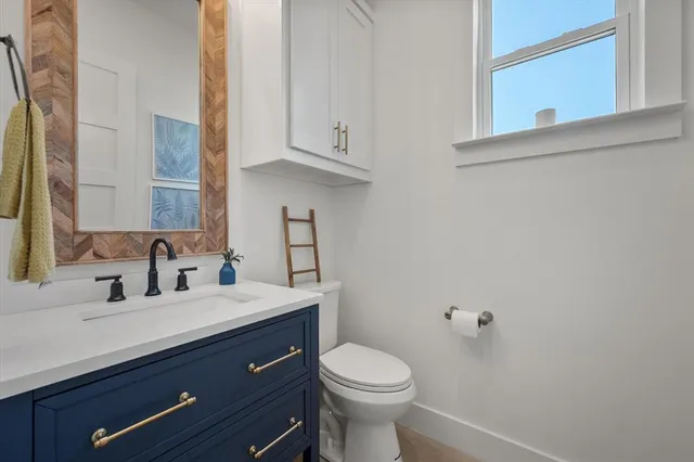 a bathroom with a sink a toilet and mirror
