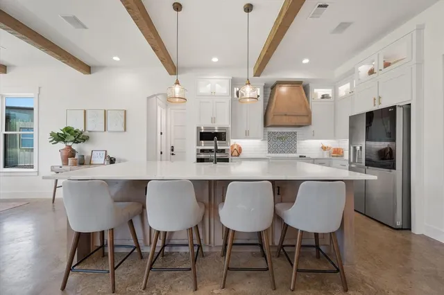 a kitchen with a table chairs refrigerator and microwave