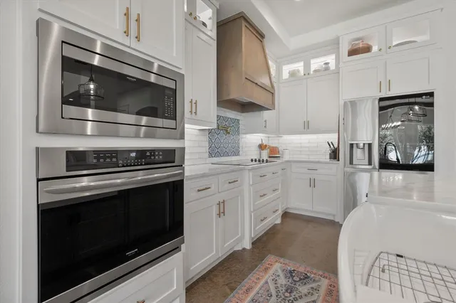 a kitchen with stainless steel appliances white cabinets and stove