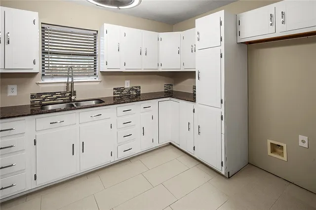 a kitchen with granite countertop white cabinets and stainless steel appliances