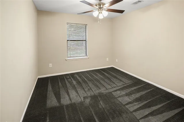 an empty room with wooden floor closet and windows