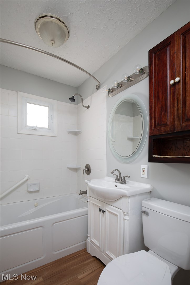 4782 Belle Meadow Road Mentor, OH 44060 - Photo 22 of 22 Full bathroom featuring a textured ceiling, tiled shower / bath combo, hardwood / wood-style floors, vanity, and toilet