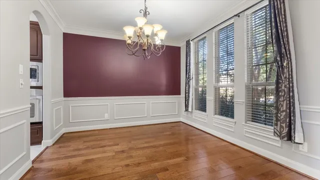 a view of a hallway with wooden floor and stairs