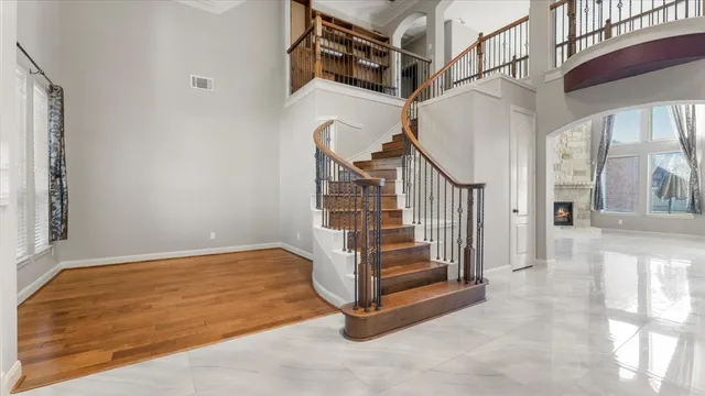 a view of a room with a large window and wooden floor