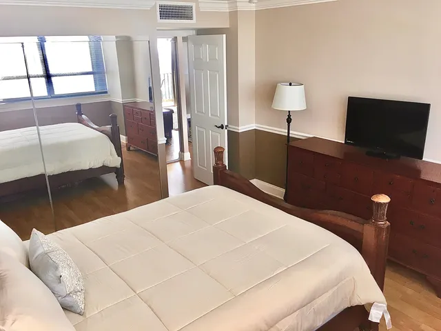 a bathroom with a granite countertop toilet sink and mirror