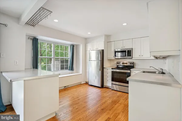 a kitchen with a refrigerator a stove top oven a sink and dishwasher