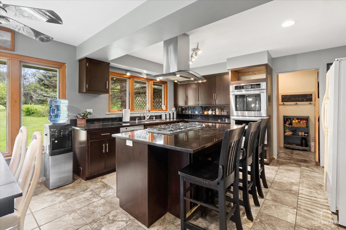 22446 North Old Barrington Road Barrington, IL 60618 - Photo 16 of 49 a kitchen with a table chairs sink and cabinets