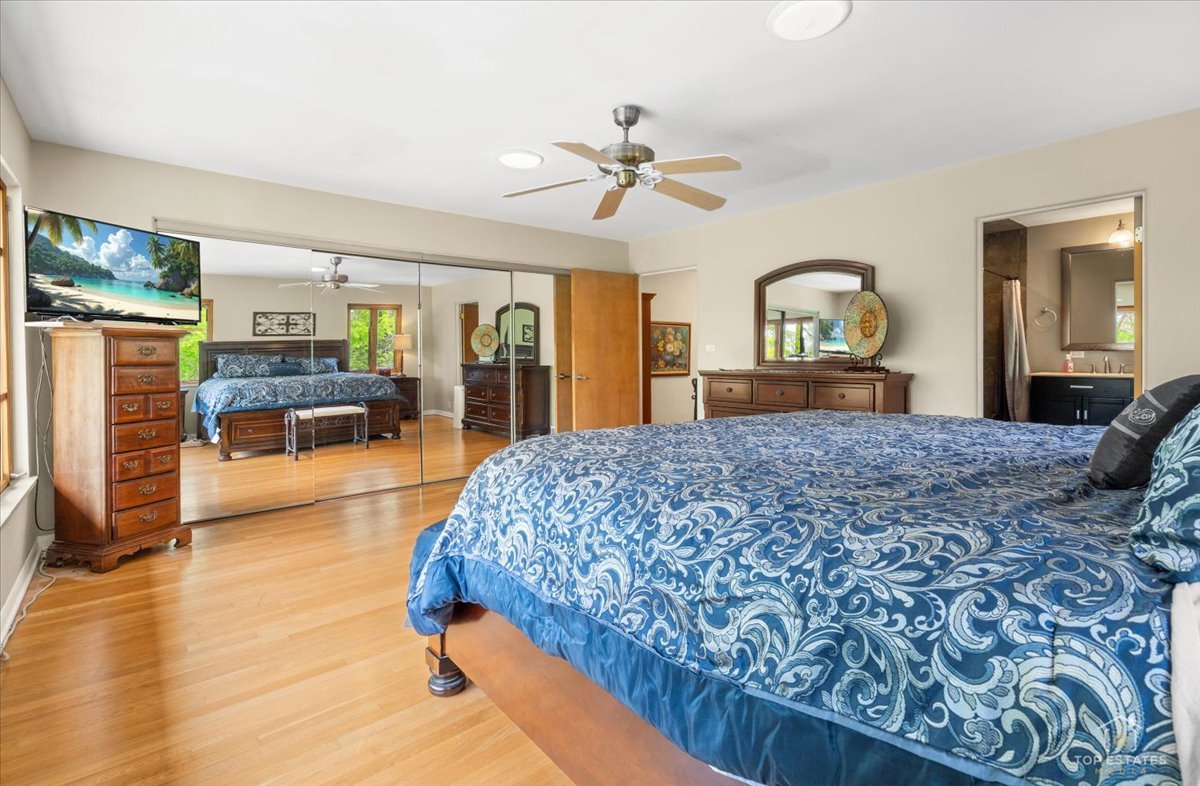 22446 North Old Barrington Road Barrington, IL 60618 - Photo 24 of 49 a bedroom with a large bed and a chandelier