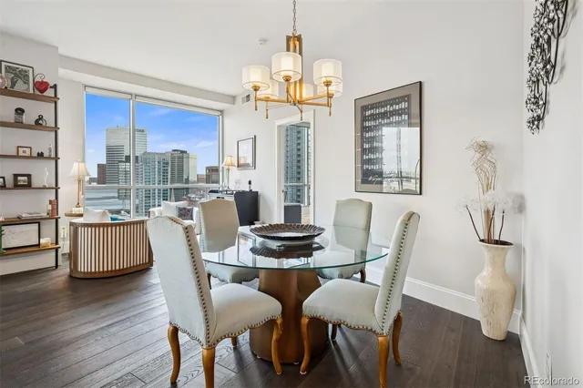 a kitchen with stainless steel appliances granite countertop a dining table chairs and a refrigerator