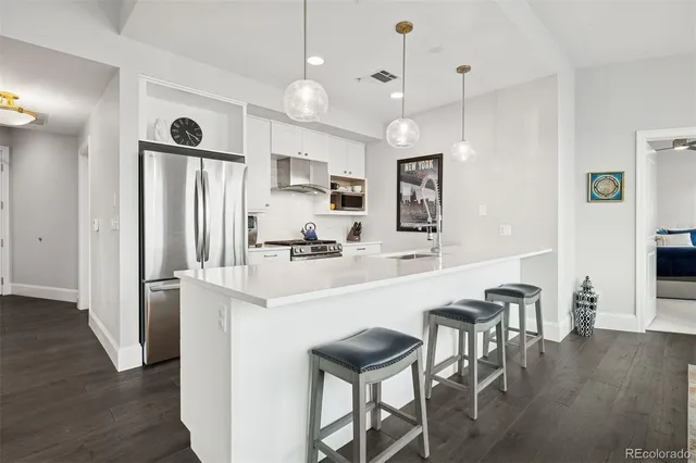 a living room with kitchen island furniture and wooden floor