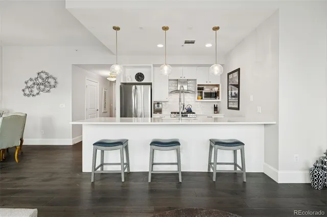 a kitchen with stainless steel appliances kitchen island granite countertop a sink and chairs