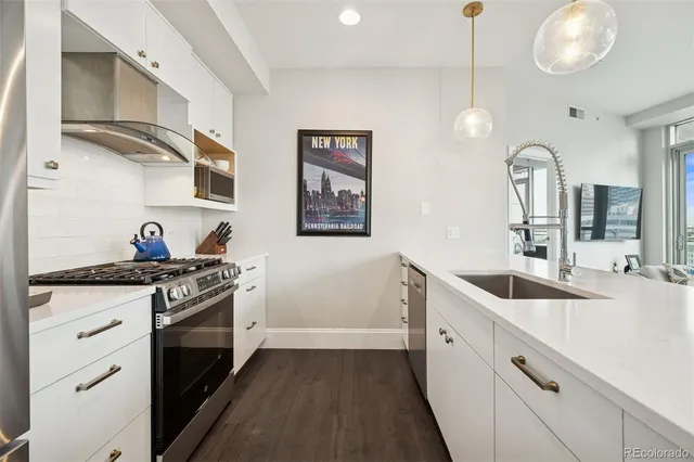 a kitchen with stainless steel appliances granite countertop white cabinets and a stove