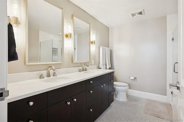 a spacious en suite bathroom with a granite countertop tub sink and mirror