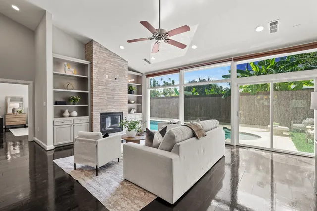a living room with furniture a fireplace and a floor to ceiling window