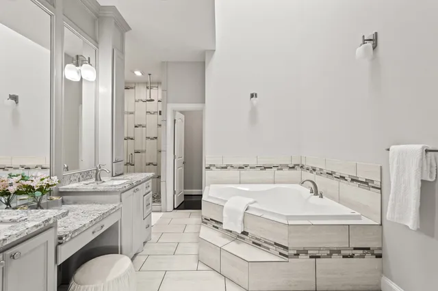 a bathroom with a tub sink and mirror