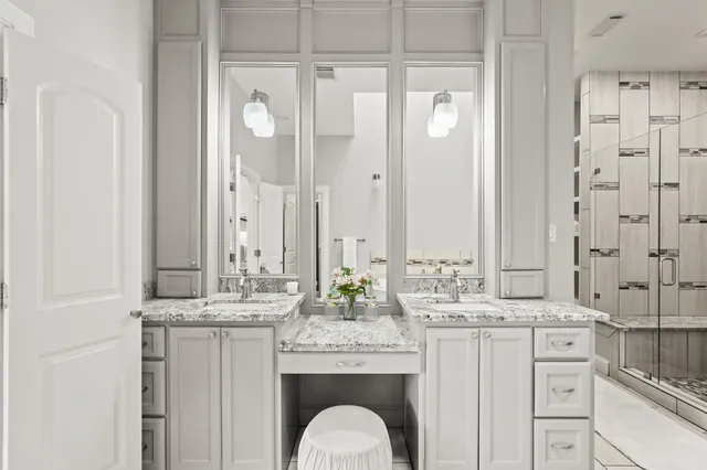 a bathroom with a granite countertop sink a mirror and a shower
