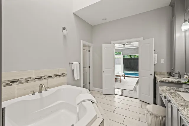 a spacious bathroom with a bathtub sink and mirror