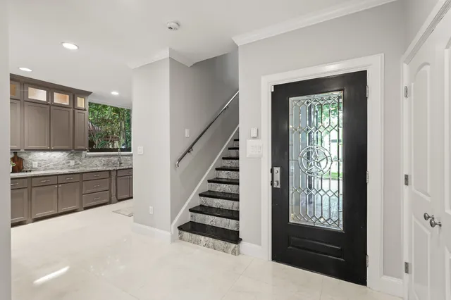 a view of kitchen with entryway and windows